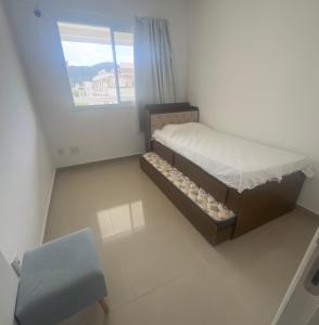 una piccola camera da letto con un letto e una finestra di Cond Twice Guaruja Sp a Guarujá