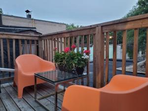 a deck with orange chairs and a table and flowers at Downtown Retreat-Spacious Rooms with Shared Kitchen & Bath in Toronto