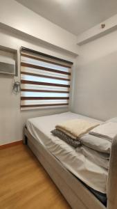 a bedroom with two beds and a window at Golden Stay Trees Residences Novaliches Quezon City in Manila