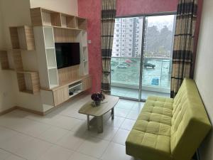 a living room with a couch and a large window at Family Stay at Quintet A3A-3A-6 in Tanah Rata