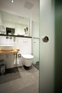 uma casa de banho com um WC branco e um lavatório. em President Hotel em Bonn