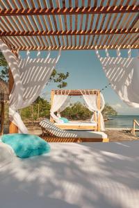 a bed with a hammock and a view of the ocean at Hotel isla bonita in Tintipan Island