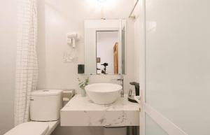 a white bathroom with a sink and a mirror at Going Merry in Hanoi +10 photos