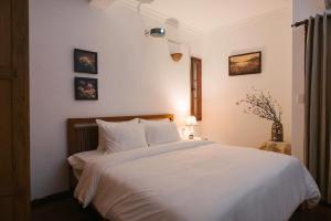 a bedroom with a large white bed with white sheets at Going Merry in Hanoi