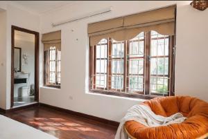 an orange couch in a room with windows at Going Merry in Hanoi