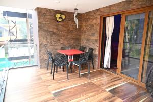 a dining room with a red table and chairs at Barnes homestay in Kalyānpur