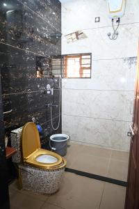 a bathroom with a toilet with a yellow seat at Barnes homestay in Kalyānpur +16 photos