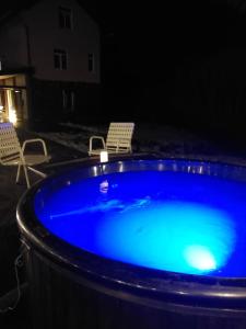 a blue hot tub with two chairs and a table at Riverside in Slavske