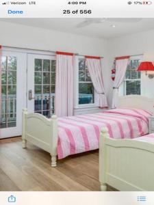 ein Schlafzimmer mit einem Bett mit einer rosa und weißen Decke in der Unterkunft Spectacular Views From This Reversed Living Home! in Harvey Cedars