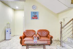 - un canapé dans une chambre avec une table et un réveil dans l'établissement Hotel O Vishwakarma Palace, à New Delhi