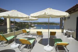 a group of chairs and umbrellas on a patio at Stella Hotel Apartments in Fiskardo