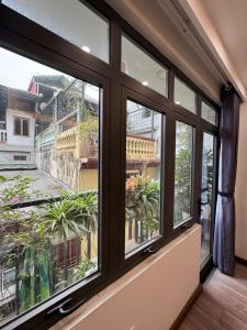 a room with windows with a view of a balcony at 54 homestay Van Mieu in Hanoi