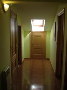 un pasillo vacío con una puerta y un tragaluz en Hostal Catro Ventos, en Lugo