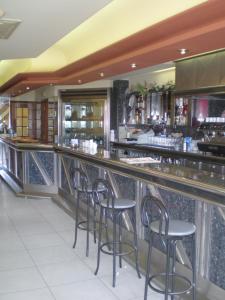 a bar in a restaurant with stools at Hostal Catro Ventos in Lugo