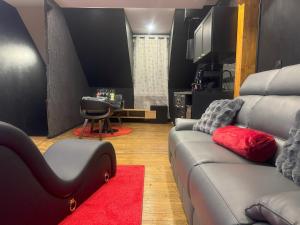 a living room with a couch and a red rug at Sweety's Eden Jacuzzi - Spa privé Sauna Cinéma room Jardin - Terrasse centre-ville in Le Mans