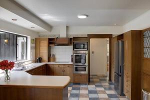 a kitchen with wooden cabinets and a counter top at Mountain Bike Manor in Rotorua +26 photos