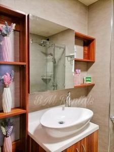 a bathroom with a white sink and a shower at Antara Residential Studio Unit BM Rentals in Talisay