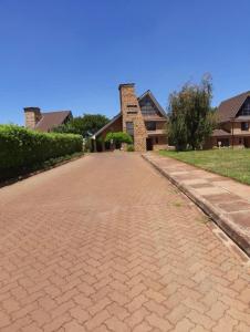 a brick road in front of a house at Golf in Kiambu