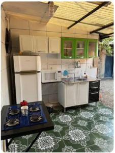 una cocina con electrodomésticos blancos y una mesa en una habitación en Quarto de Pedra, en Cuiabá
