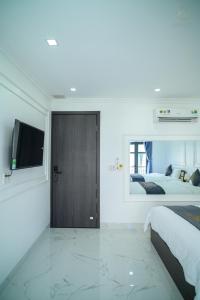 a bedroom with two beds and a door with a television at 6668 Hotel - Chi nhánh 1 in Tây Ninh