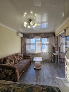 a living room with a couch and a table at Lux Apartment on Mayakovsky 6 in Ustʼ-Kamenogorsk