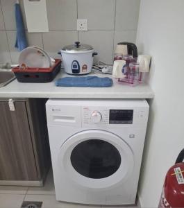 a kitchen counter with a washing machine in a kitchen at Aura Homestay - Edusphere Suites in Cyberjaya