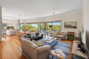 Una sala de estar con sofás y una mesa y una cocina. en Bay Haven, en Dunsborough