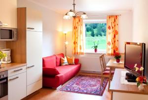 ein Wohnzimmer mit einem roten Sofa und einem Fenster in der Unterkunft Haus Nadja in Bad Kleinkirchheim