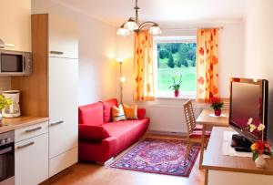 a living room with a red couch and a window at Haus Nadja in Bad Kleinkirchheim