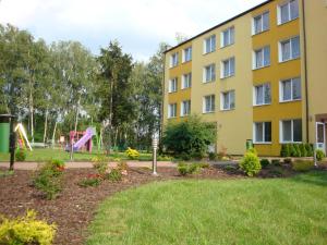 a building with a playground in a park at Obiekt Tatar - Usługi Hotelarskie in Rawa Mazowiecka