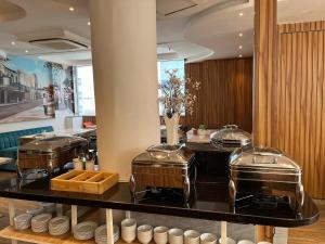 un restaurante con una barra con ollas y sartenes en Nicecy Hotel Suites & Spa, en Ho Chi Minh