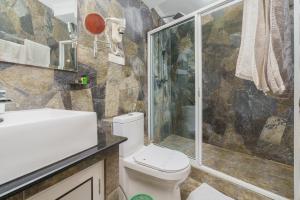un bagno con doccia, WC e lavandino di Hotel Travellers Nest Kandy a Kandy