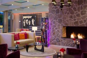 a living room with a fireplace and a woman standing next to it at N’vY Manotel in Geneva