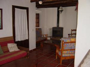 - un salon avec un canapé et une cuisinière dans l'établissement Cortijo Retarta Jubrique, à Jubrique