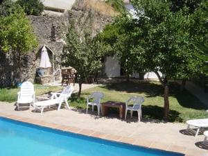 a group of chairs and tables next to a pool at Cortijo Retarta Jubrique in Jubrique