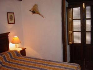 une chambre avec un lit, une lampe et une fenêtre dans l'établissement Cortijo Retarta Jubrique, à Jubrique 36 autres photos
