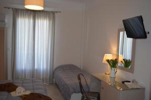 ein Wohnzimmer mit Sofa und Fernseher in einem Zimmer in der Unterkunft Archontissa in Ermoupoli