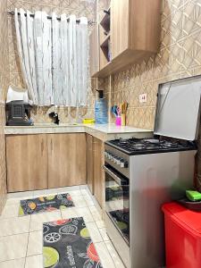 a kitchen with a stove and a refrigerator at Soft Greys Homes in Mombasa +7 photos