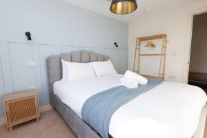 a bedroom with a large bed with white pillows at Cohost Partners Albert Hall 3 min to City Centre in Swansea