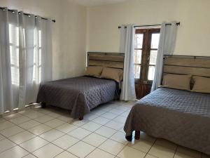 une chambre avec deux lits et une fenêtre dans l'établissement Apartamentos en el centro con vistas a la iglesia y al andador, à Calvillo