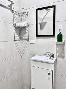 une salle de bain blanche avec un lavabo et un miroir dans l'établissement Apartamentos en el centro con vistas a la iglesia y al andador, à Calvillo