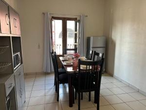 une cuisine avec une table avec des chaises et un réfrigérateur dans l'établissement Apartamentos en el centro con vistas a la iglesia y al andador, à Calvillo 9 autres photos