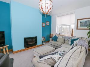 a living room with a couch and a tv at Ty'r Orsaf in Builth Wells