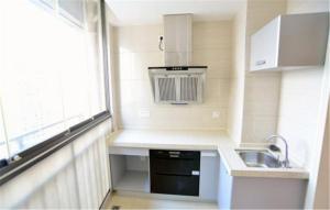 una pequeña cocina con fregadero y ventana en Nanning Qingzhou Rental Apartments, en Nanning