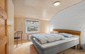 a bedroom with a bed in a room with a window at Nice Home In Blåvand With Sauna in Blåvand +16 photos