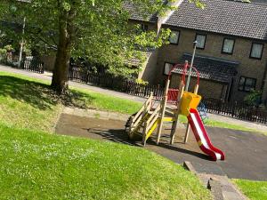 a playground with a slide in a park at In the heart of central London in London
