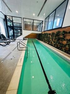 a swimming pool with green water in a building at Spacious Magnificent Sea Views Front of Sky Tower in Auckland