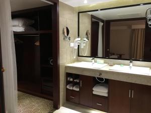 a bathroom with two sinks and a large mirror at Hôtel Huatian Chinagora in Alfortville