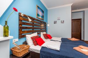 um quarto com paredes azuis e uma cama com almofadas vermelhas em Hotel Ekaterinhof em São Petersburgo