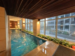 a large swimming pool in a building with windows at 1 BR 1 BATH, Southern Cross, Balcony in Melbourne